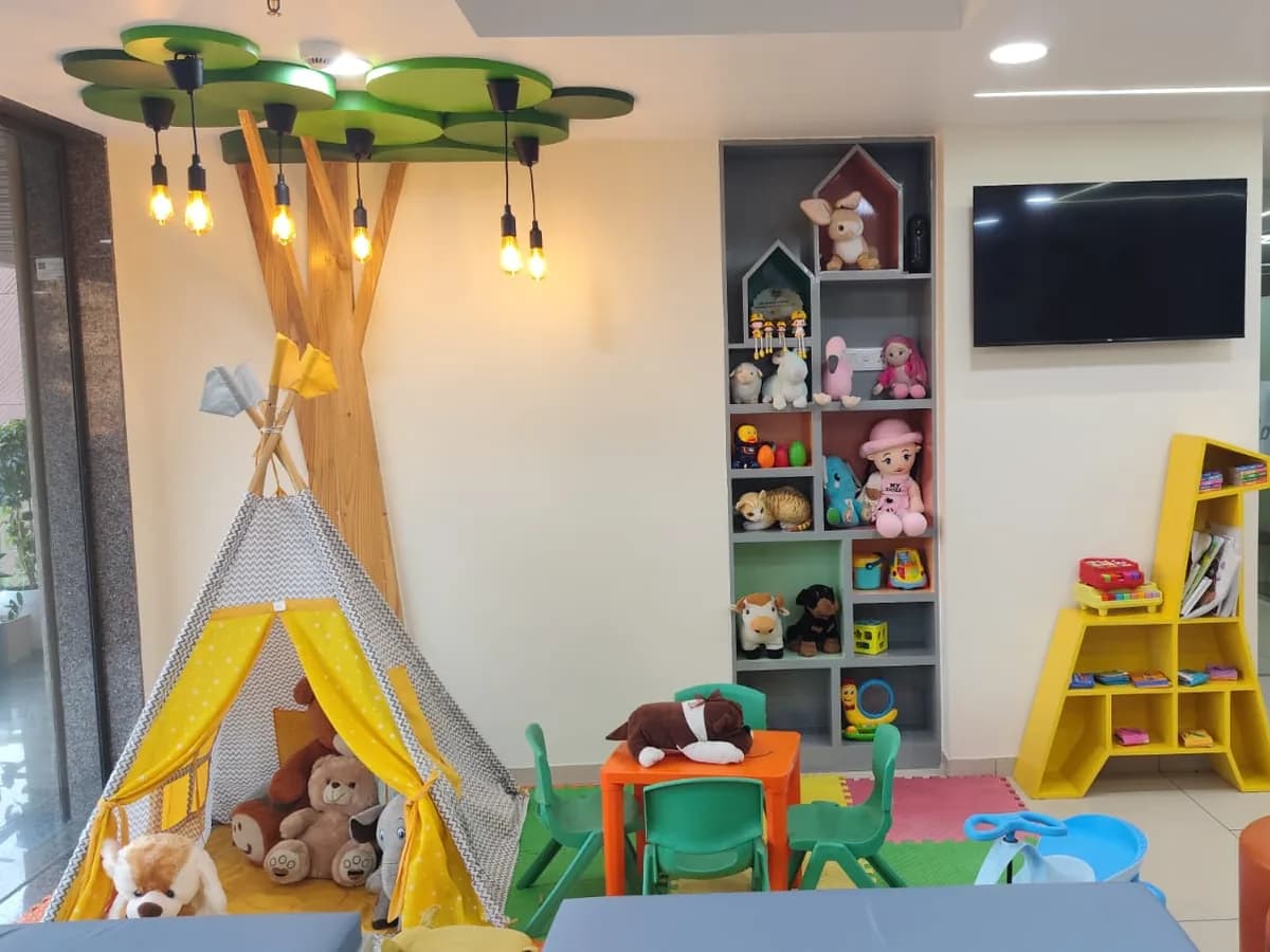 Children's play area with toys, books and a play tent in the waiting area at GROW Children Hospital, Ahmedabad